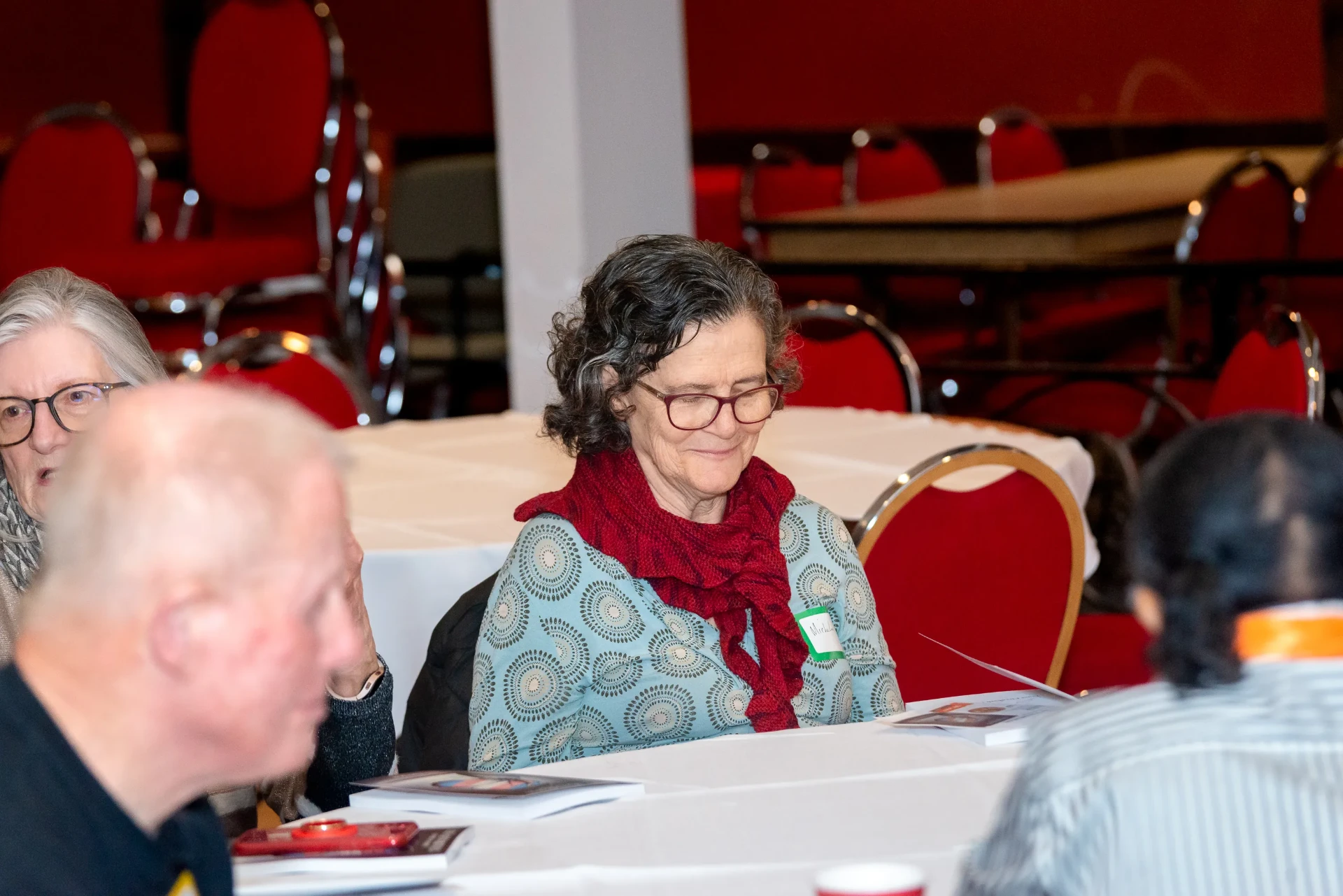 A reader looks down at the book at her table